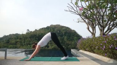 Esmer kadın havuz kenarında yoga egzersizi yapıyor. Rahibe Yogi.