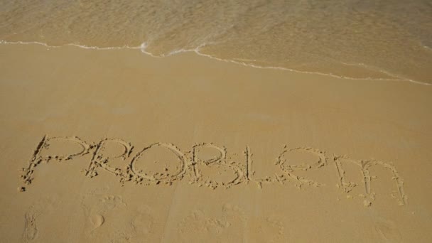 Inscription sur le bord de mer. vague de la mer lavé le problème de mot. Mouvement lent — Video