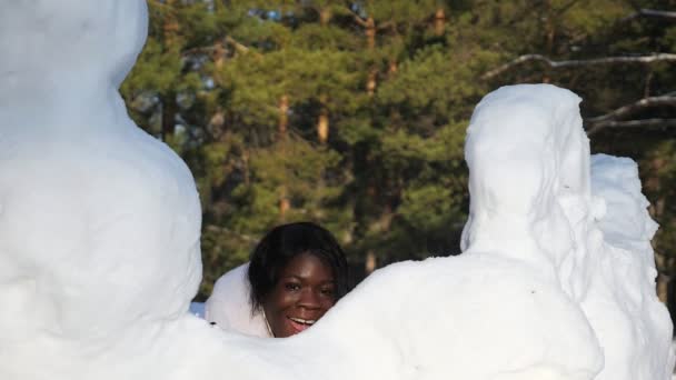 Ragazza dalla pelle scura si nasconde dietro cumuli di neve divertirsi — Video Stock