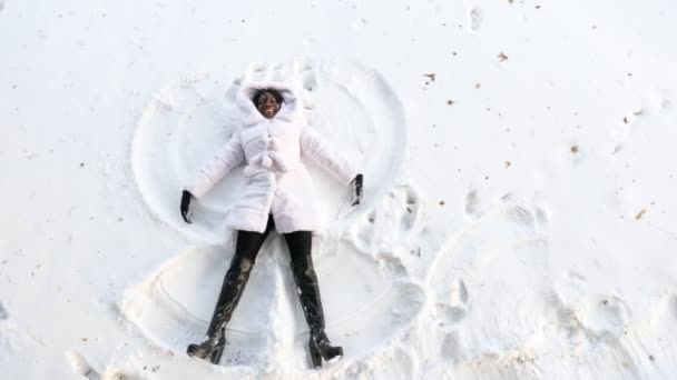 Nero ragazza si trova su bianco foresta radura e rende neve angoli — Video Stock