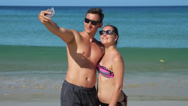 Família sorrindo faz selfie na praia ensolarada perto do oceano azul — Vídeo de Stock