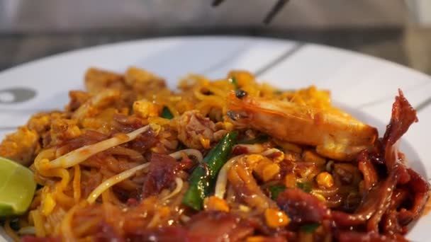 Alguém está comendo macarrão tailandês com pauzinhos — Vídeo de Stock