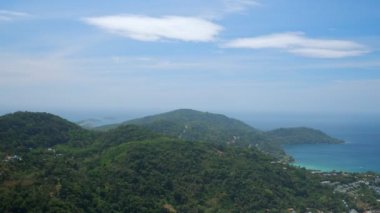 Mavi okyanus yakınında yeşil ormanları olan muhteşem bir tepe.