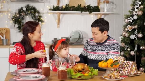 Père nourrit fille assis avec femme à la table festive — Video