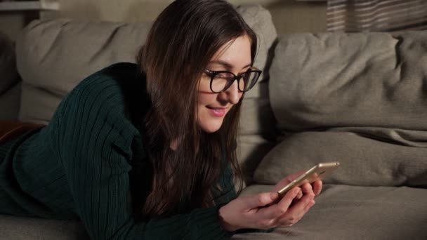 Fiatal nő zöld pulóverben telefonnal — Stock videók