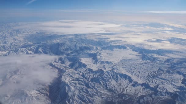 Distância gama de montanhas contra o céu azul da janela do avião — Vídeo de Stock