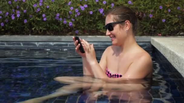 Typ kobiety na nowoczesnym smartfonie i urządzenie wpada do wody basenowej — Wideo stockowe