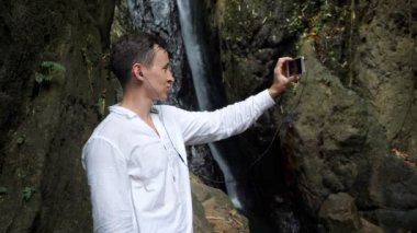 Koyu renk saçlı adam kulaklık kullanıyor ve video görüşmesi yapıyor.