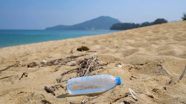 Plastik şişe ve deniz kenarındaki kumun üzerindeki farklı çöpler.,