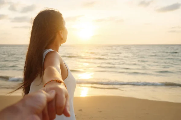 Souriant femme cours tenant petit ami main le long de la côte de l'océan — Photo