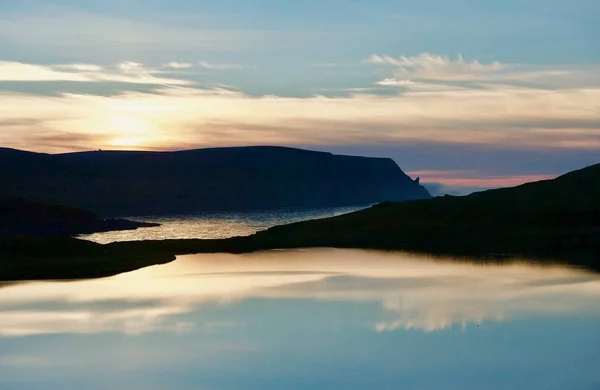 在挪威的极地白色的夜晚 山的剪影和太阳和云彩的反射在水 — 图库照片