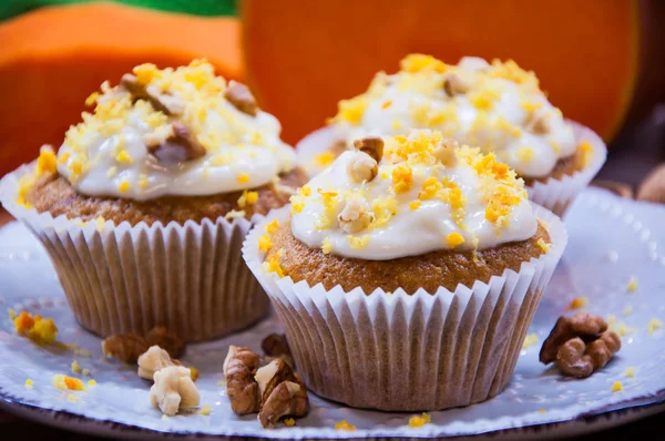 Pompoen cupcakes met crème en pompoen op een tafel — Stockfoto