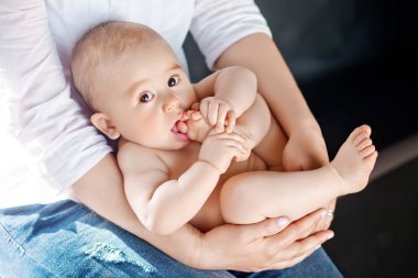 Erkek Bebek onun arkasında yatan ayak berbat. Çocuğunu holding anneler eller