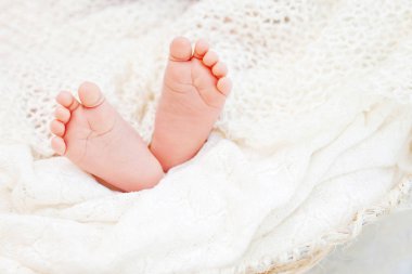 Yeni doğan bebek ayakları üzerinde örme şal resmini kapatın. Mutlu 