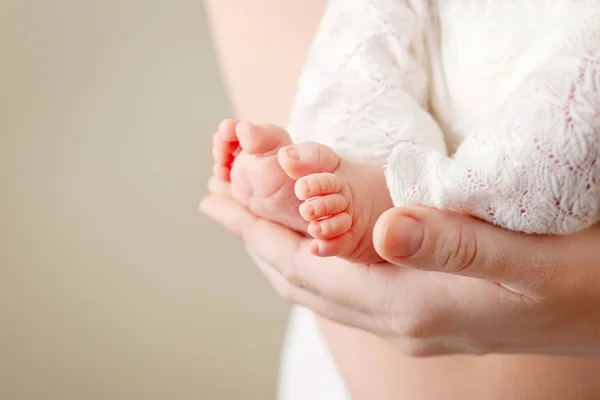 Stopy dziecka w rękach matki. Tiny nowo narodzonego dziecka jego nogi na kobiece Sh — Zdjęcie stockowe
