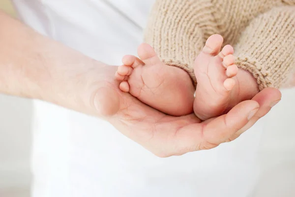 Pés de bebé nas mãos do pai. Pequenos pés de bebê recém-nascido na mão masculina — Fotografia de Stock