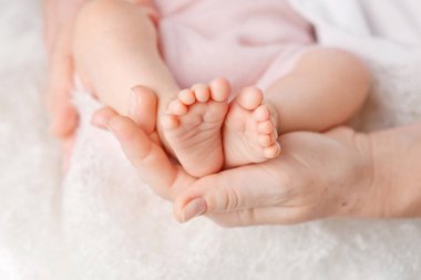 Bebe ayak anne elinde. Küçük yeni doğan bebeğin ayakları üzerinde kadın Sh