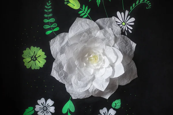 Decorative flowers from paper on a black background.  Drawing ch