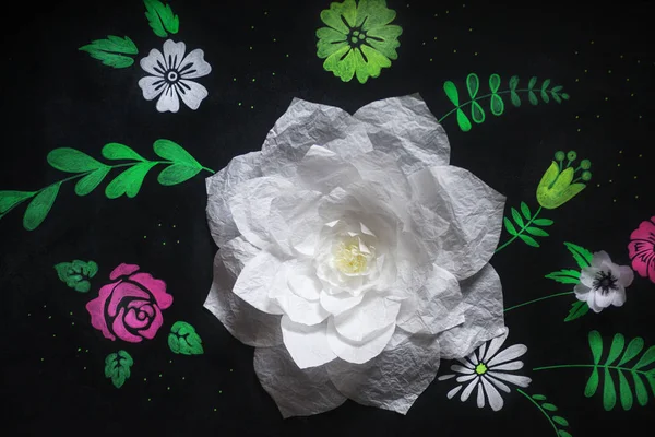 Decorative flowers from paper on a black background.  Drawing ch