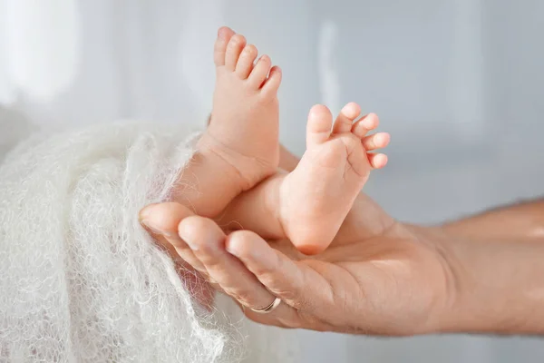 Pieds de bébé entre les mains du père. Petit nouveau-né pieds de bébé sur mâle shap — Photo