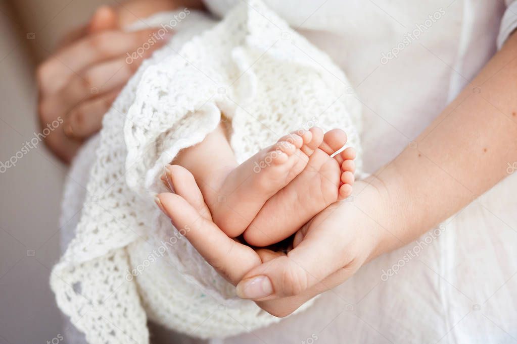Baby feet in mother hands. Tiny Newborn Baby's feet on female Sh