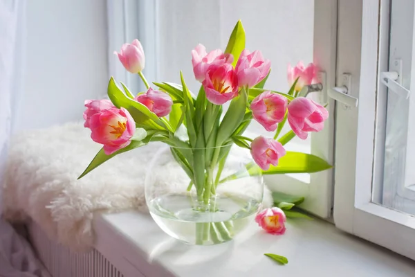 Tulipani rosa in un vaso di vetro sul davanzale bianco — Foto Stock