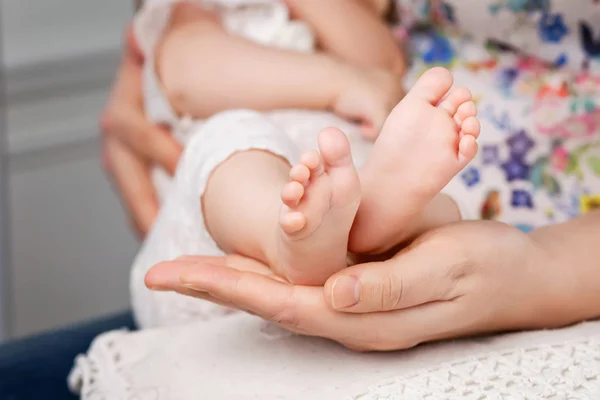 Pés de bebé nas mãos da mãe. Pequenos pés de bebê recém-nascido na fêmea Sh — Fotografia de Stock