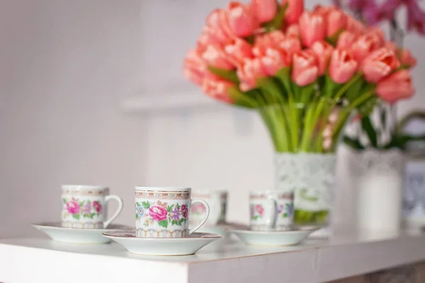 Csészék és a csokor virágot az asztalra — Stock Fotó