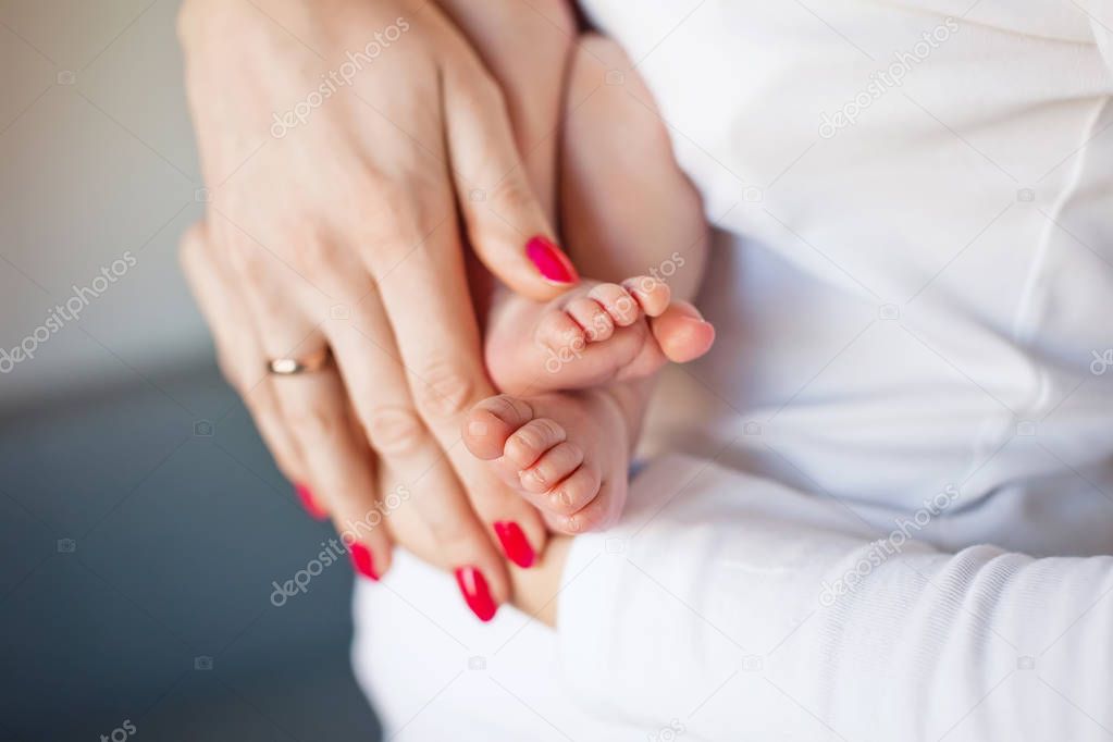 Baby feet in mother hands. Tiny Newborn Baby's feet on female Sh