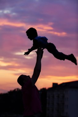 Baba ve oğul sahilde günbatımı anda oynamak. Kavramı 