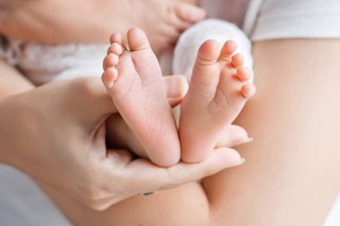 Bebe ayak anne elinde. Küçük yeni doğan bebeğin ayakları üzerinde kadın Sh