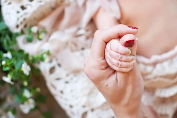 La mano de los niños recién nacidos en la mano materna. Mamá y su hijo — Foto de Stock
