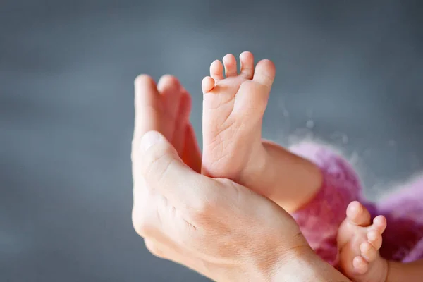 Pés de bebé na mão dos pais. Pequenos pés do bebê recém-nascido em forma han — Fotografia de Stock