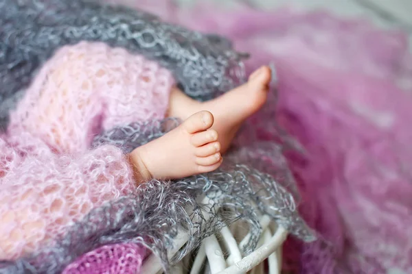 Κοντινό πλάνο εικόνα του νέο-γεννημένο μωρό πόδια σε ένα γκρι και ροζ καρό — Φωτογραφία Αρχείου