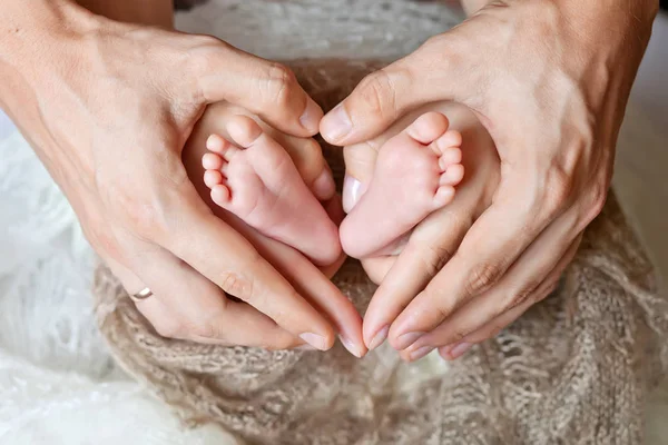 Barns fötter i händerna av mor och far. Fötterna på den lilla — Stockfoto
