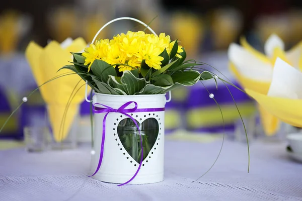 Жовті квіти в білій вазі на столі. Весільна прикраса — стокове фото