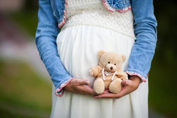 Ближе к беременному животу. Женщина ждет ребенка с милой Т — стоковое фото