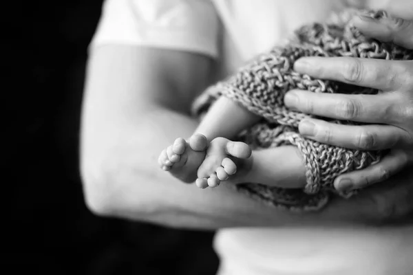 Pieds de bébé entre les mains du père. Photo en noir et blanc. Pieds de bébé dans — Photo