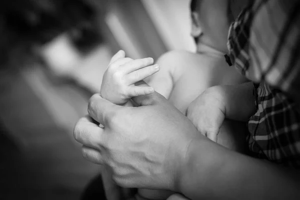 La mano de los niños recién nacidos en la mano materna. Foto en blanco y negro . — Foto de Stock