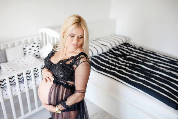 Krásná těhotná žena stát v černé a bílé domácím místnosti — Stock fotografie