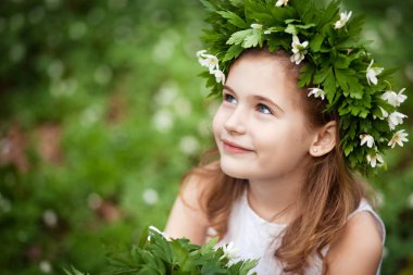 Beautiful  little girl in a white dress  in the spring wood. Por clipart