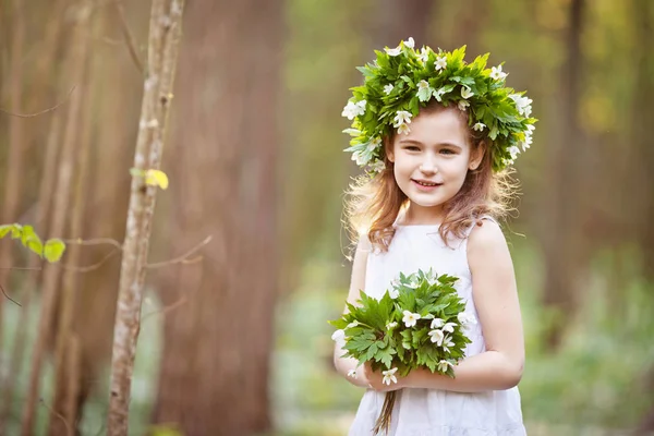 Schönes kleines Mädchen in weißem Kleid spaziert im Frühlingswald — Stockfoto