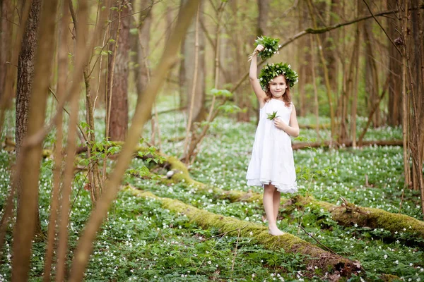 Menina bonita em um vestido branco caminha na madeira de primavera — Fotografia de Stock