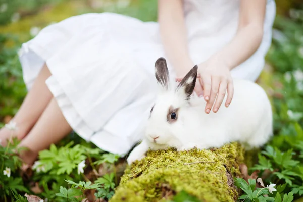 Belle petite fille dans une robe blanche plaçant avec lapin blanc — Photo