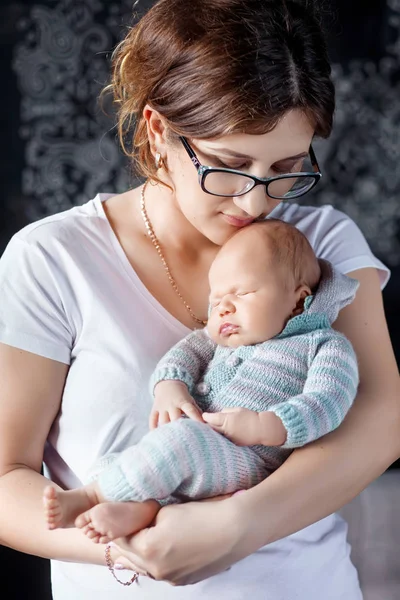 Hübsche Frau hält ein neugeborenes Baby im Arm — Stockfoto