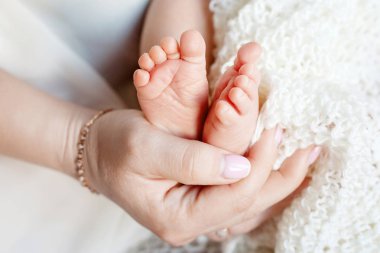 Bebe ayak anne elinde. Küçük yeni doğan bebeğin ayakları üzerinde kadın Sh