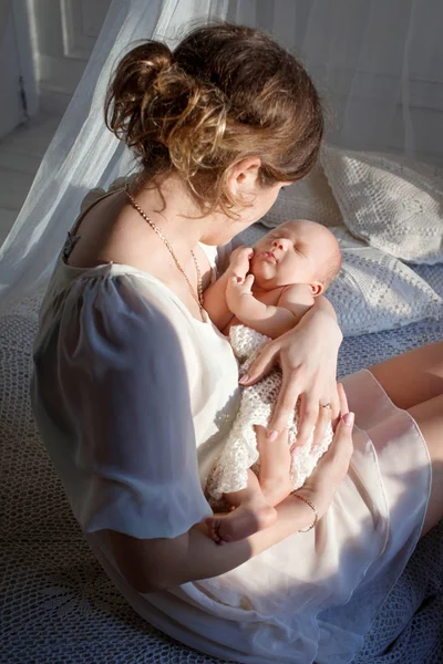 Glückliche Familienmutter spielt und umarmt Neugeborenes im Bett — Stockfoto