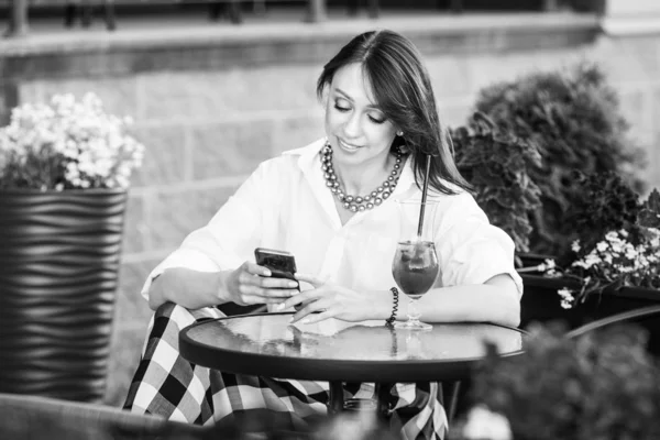 Femme heureuse dans un café de rue lisant un message texte de son pho — Photo