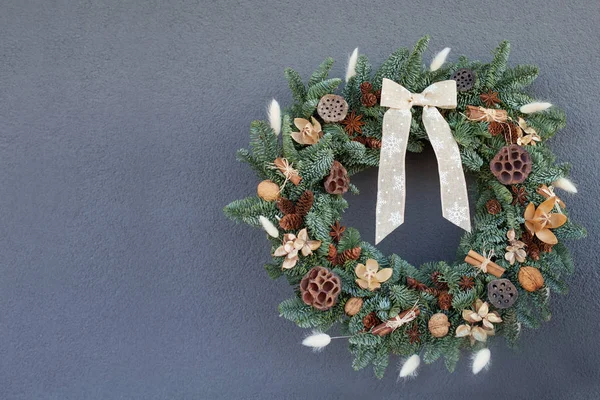 Grinalda de Natal feita de ramos de abeto naturais pendurados em um cinza — Fotografia de Stock