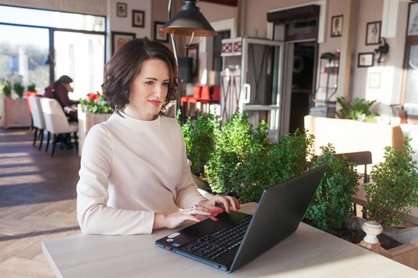 Adulte élégante femme d'affaires en robe blanche assis avec ordinateur portable i — Photo